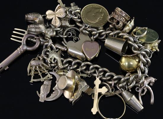 A 9ct gold curb link charm bracelet, hung with twenty nine assorted charms, including a 1911 half sovereign, gross 93 grams.